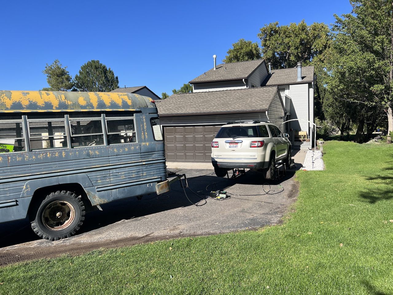 The Wolf Pack Repair service bus parked alongside a customer&rsquo;s SUV on jack stands in a Pocatello driveway